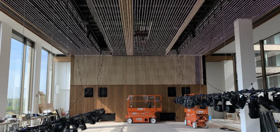 Rendu final immersif du projet. Le plafond et le mur LED sont allumés et diffusent un motif vidéo abstrait bleu et violet, tandis que les projecteurs scéniques éclairent la scène avec des faisceaux chauds.